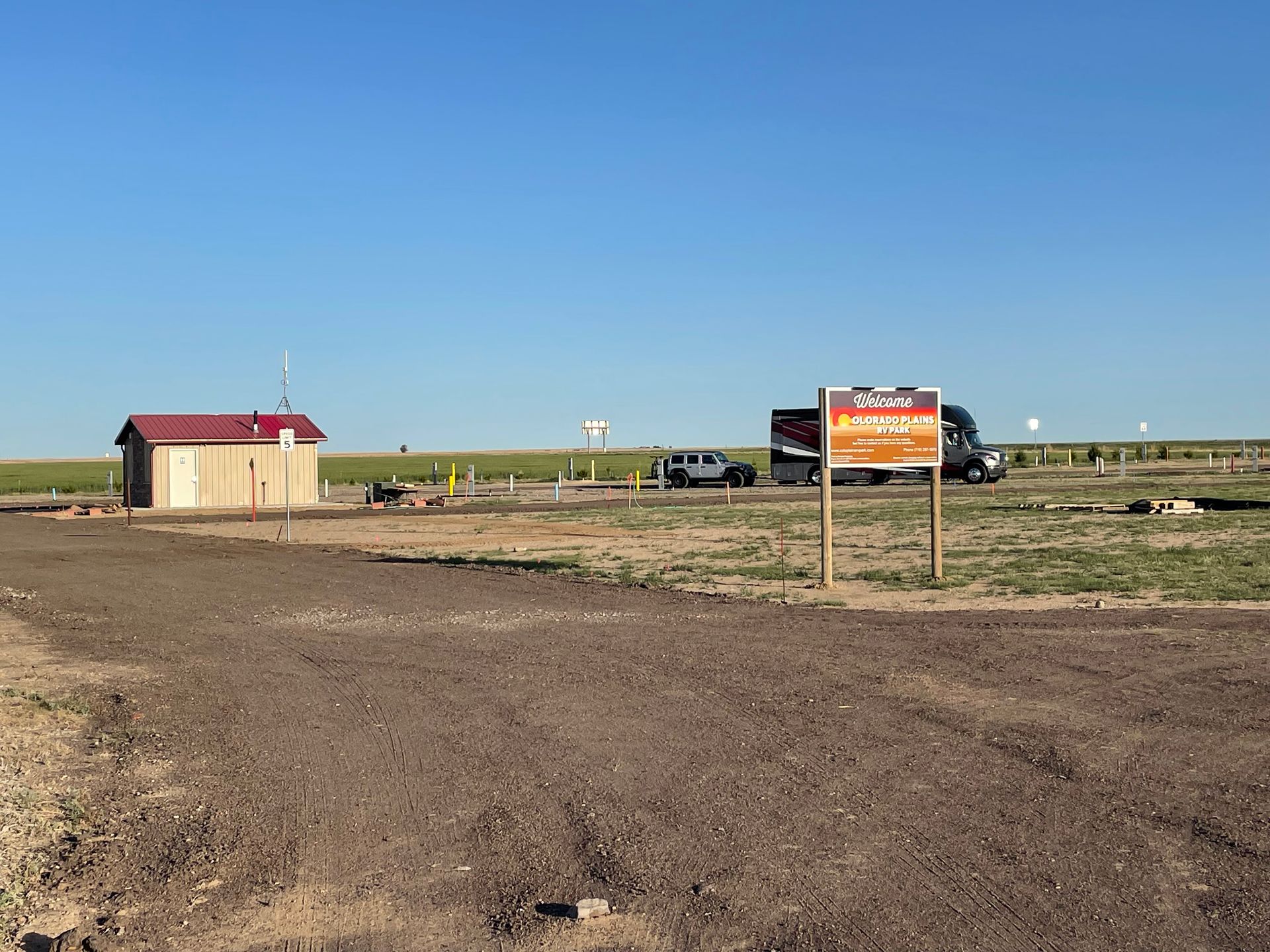 A sign in the middle of a dirt field says welcome