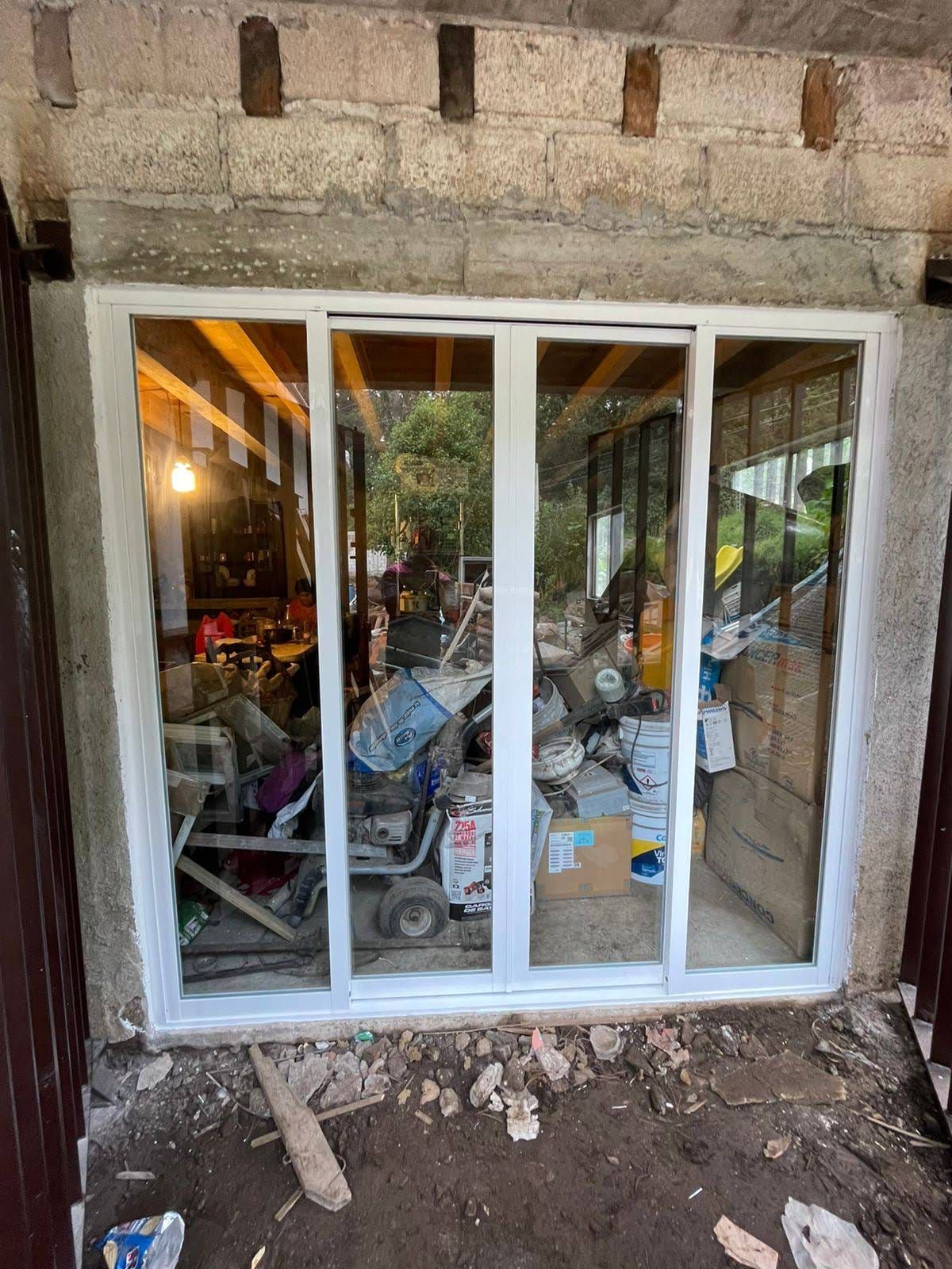 Se está instalando una puerta corrediza de vidrio en un garaje.