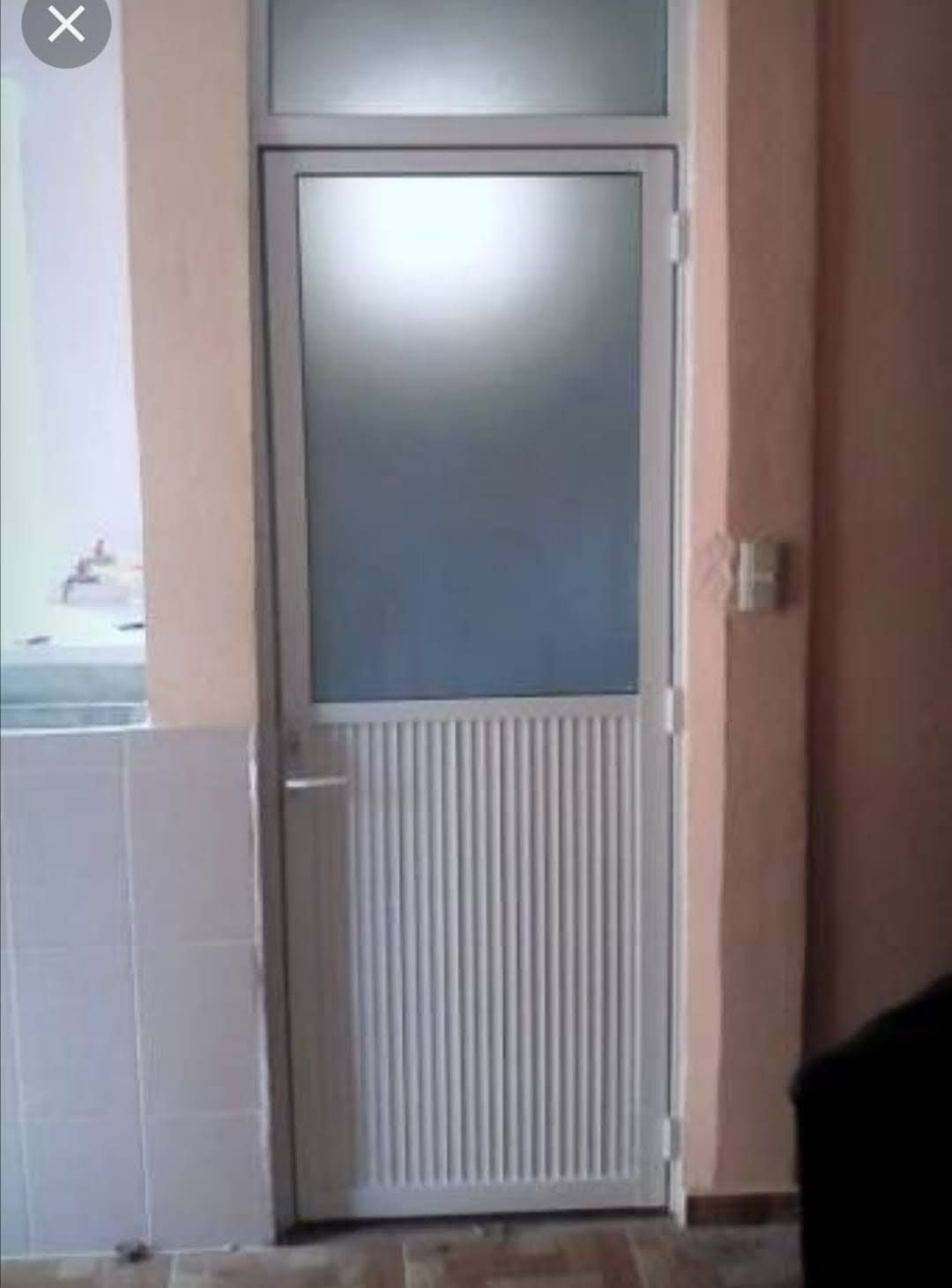 Una puerta blanca con una ventana de vidrio en una habitación.