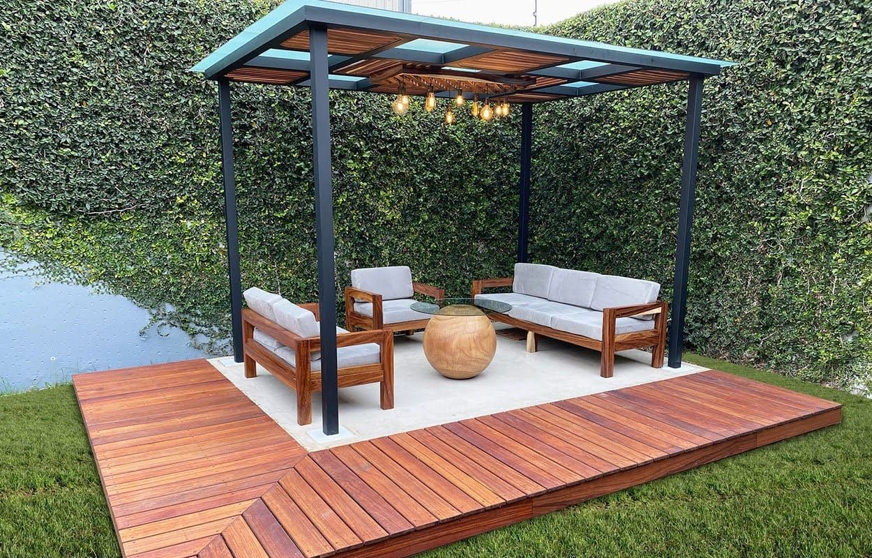 Una terraza de madera con un sofá y sillas bajo una pérgola.