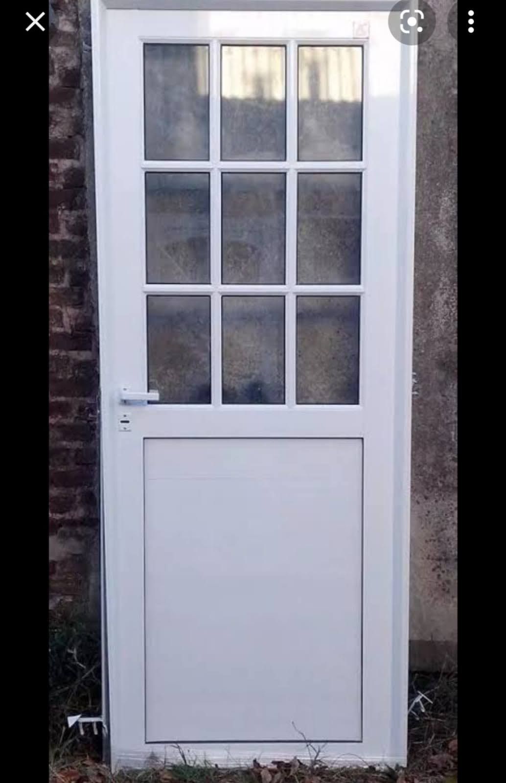 Una puerta blanca con una pared de ladrillos al fondo.