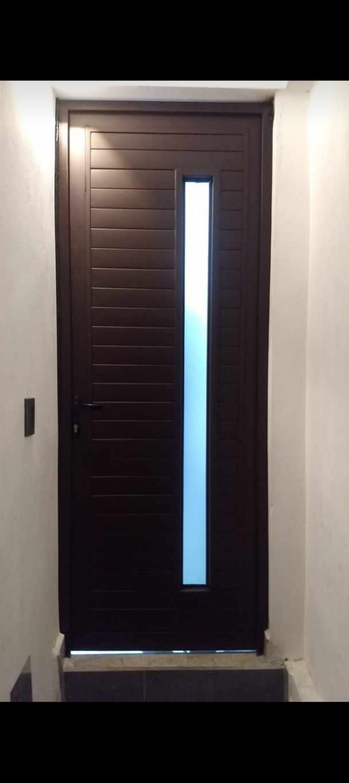 Una puerta marrón con una ventana de vidrio en una habitación.