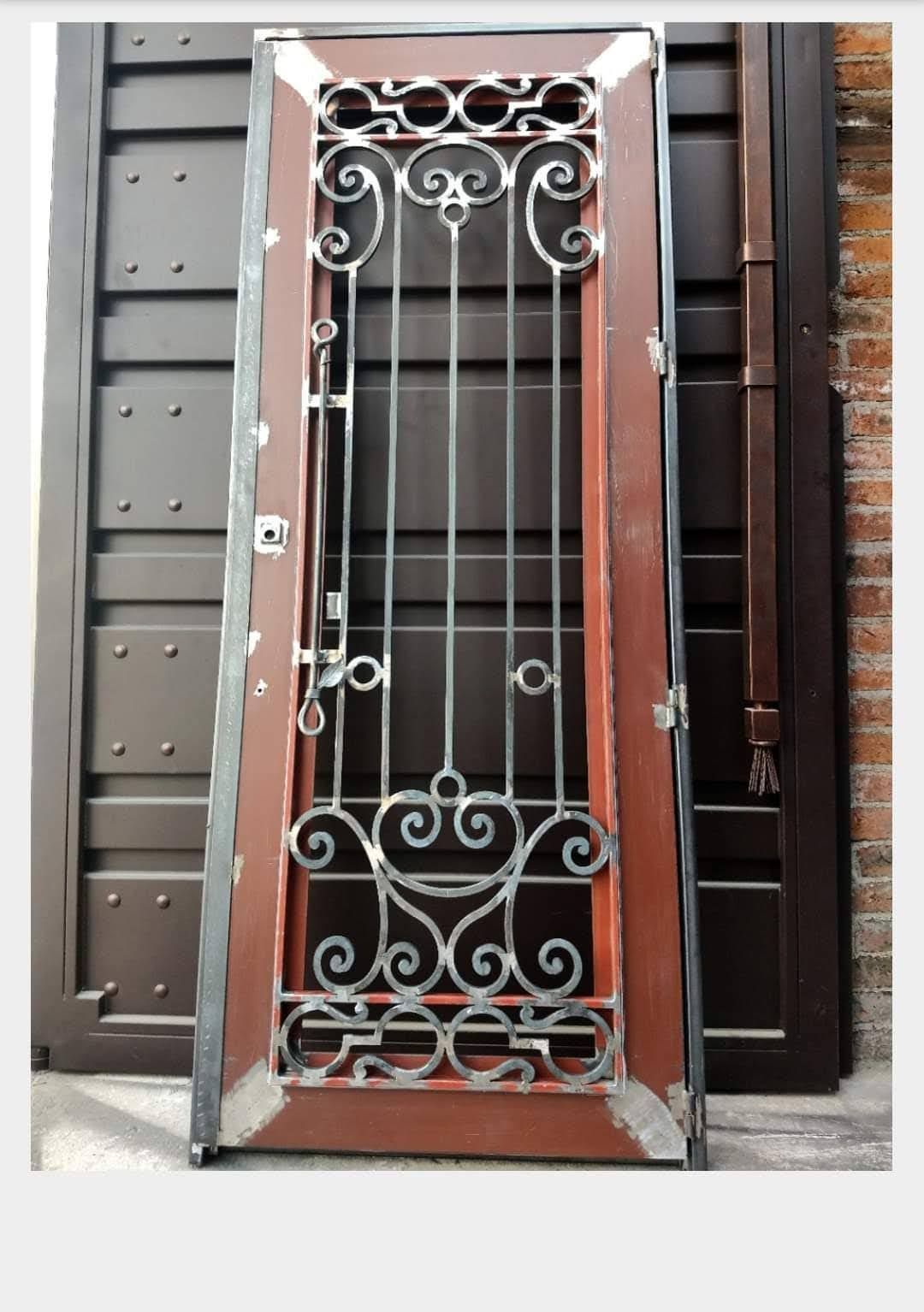 Una puerta de madera con un diseño de hierro forjado.