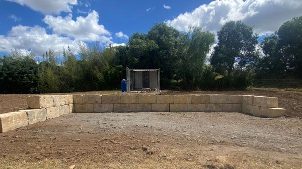 A building is being built in the middle of a dirt field.