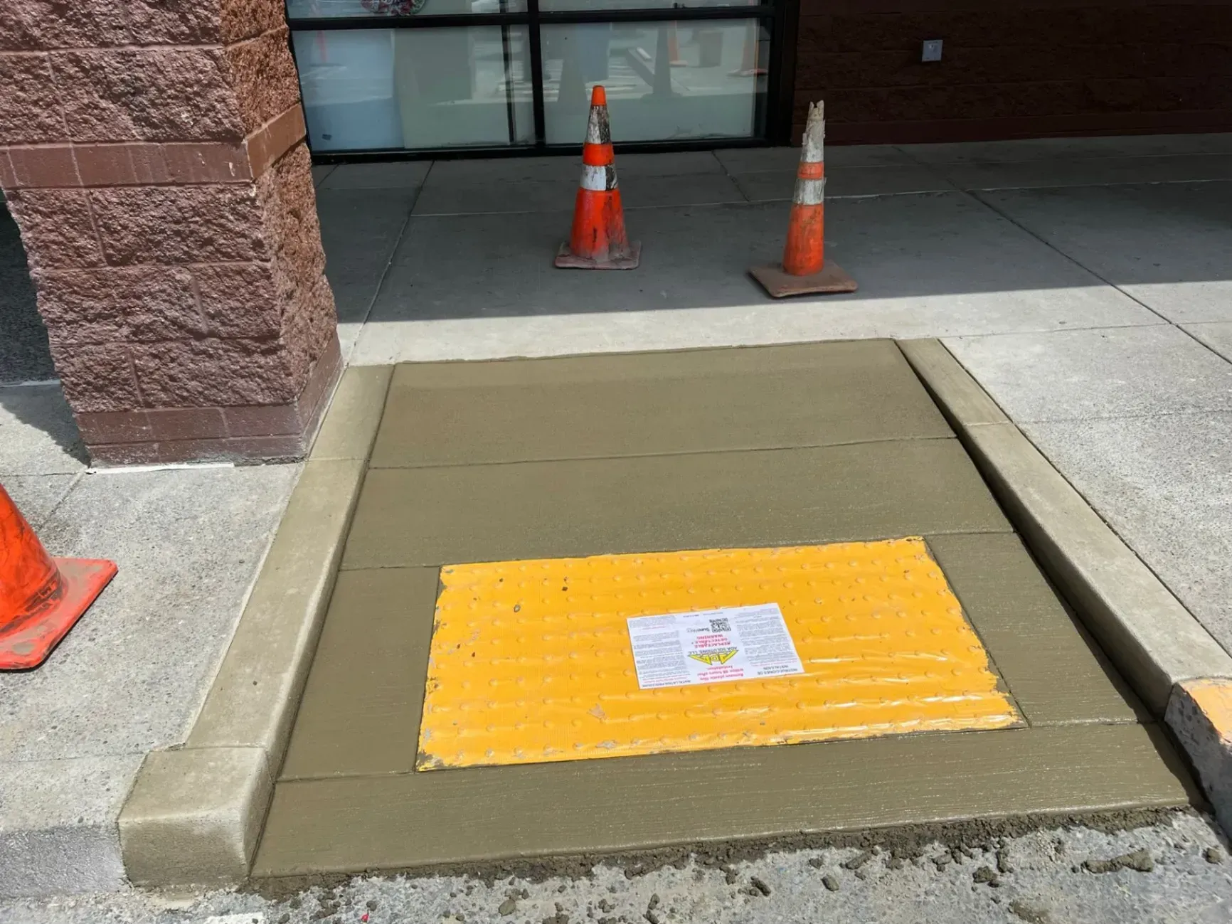 A concrete walkway with a yellow sign on it