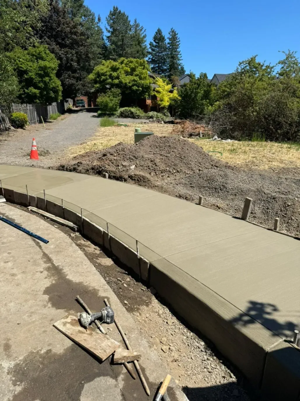 A concrete walkway is being built in a yard