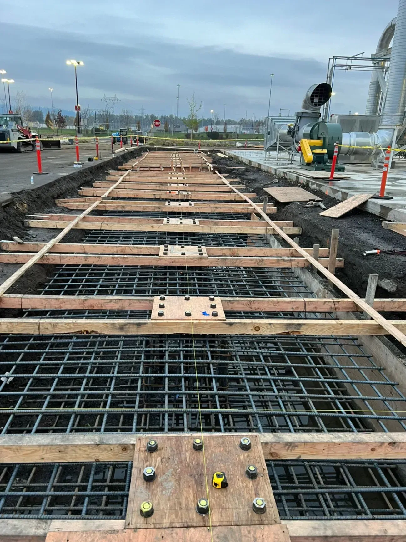 A concrete walkway is being built in a parking lot.