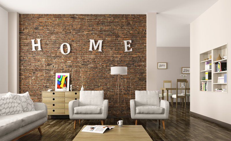 A modern living room with white and tan interior design with letters on a brick wall spelling out HOME