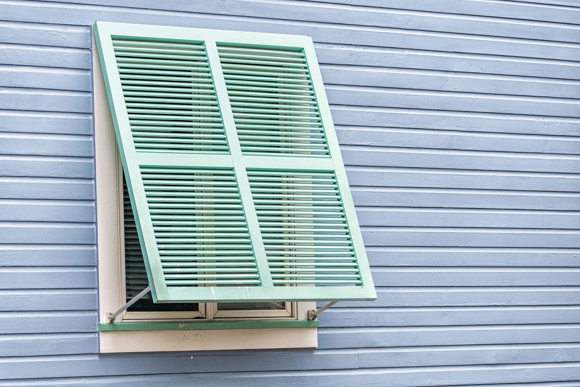Aqua shutter open on blue siding.
