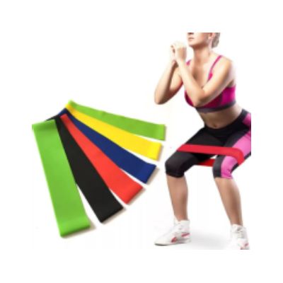 Una mujer está acostada sobre una esterilla de yoga con una banda de resistencia amarilla alrededor de su pierna.