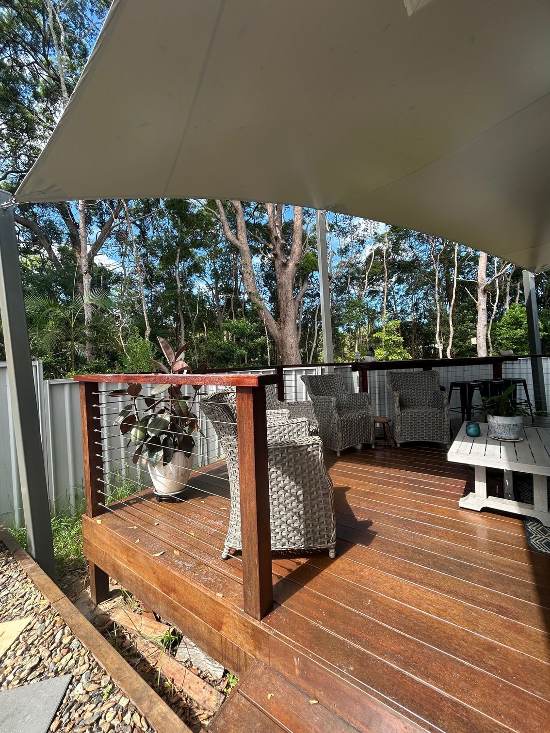 A Deck With A Chair And A Cream Shade Sail Over It — Sunshine Shade & Sails In Woombye, QLD