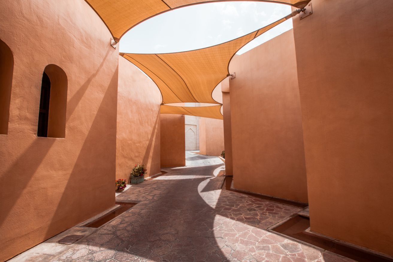 A Narrow Alleyway Between Two Buildings With A Shade Sail Over It — Sunshine Shade & Sails In Brisbane, QLD