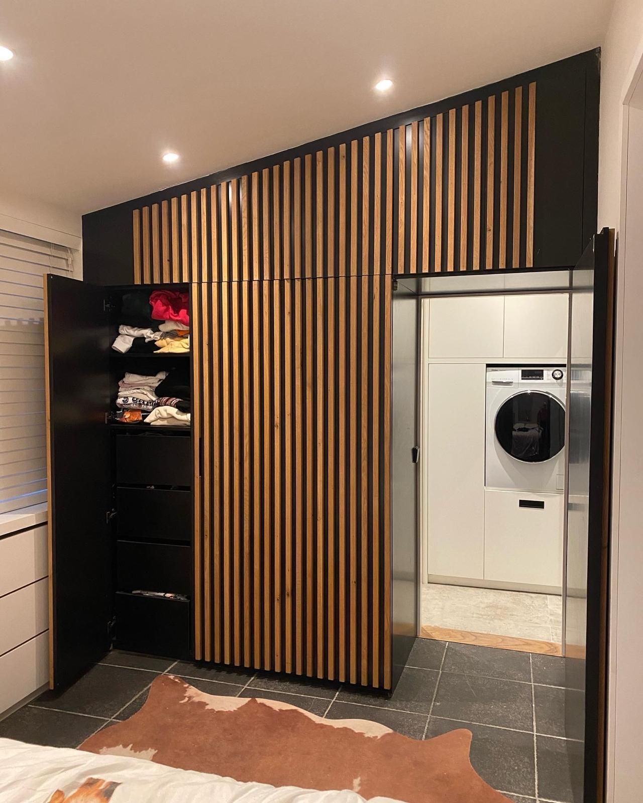 Een slaapkamer met een schuifdeur naar een wasruimte.