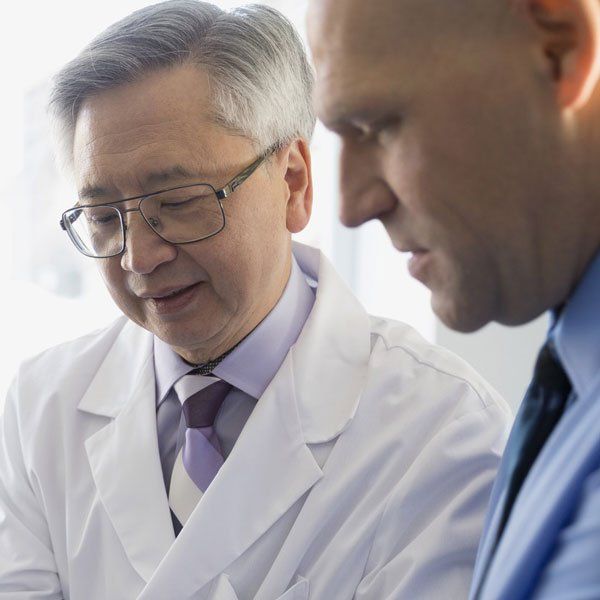 Male doctor checking a man's wrist