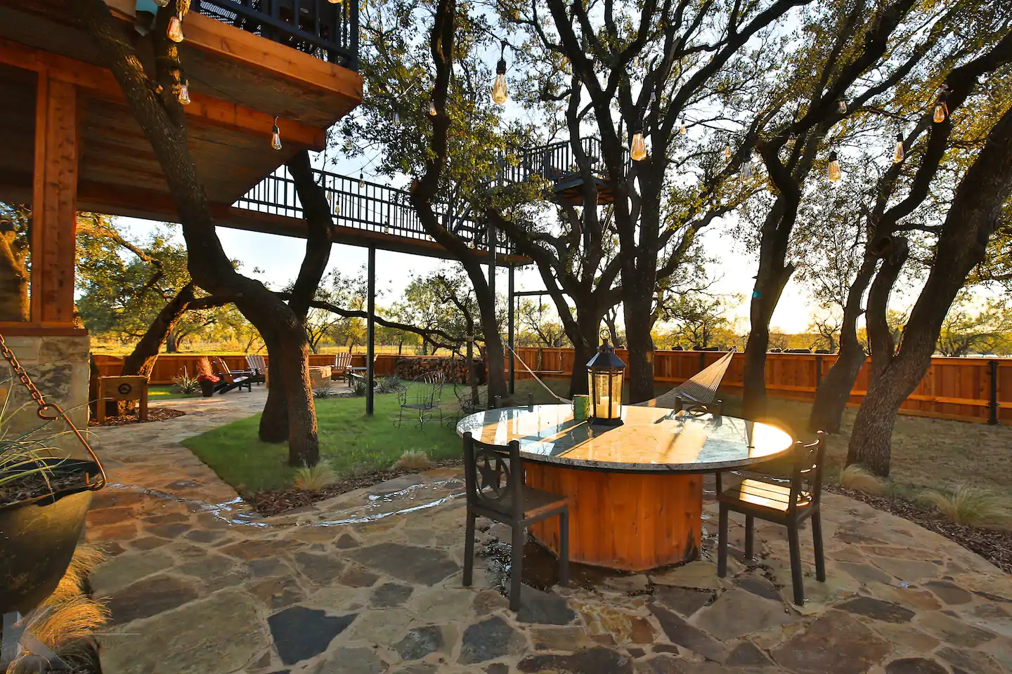 A patio with a table and chairs in the middle of it treehouse airbnb