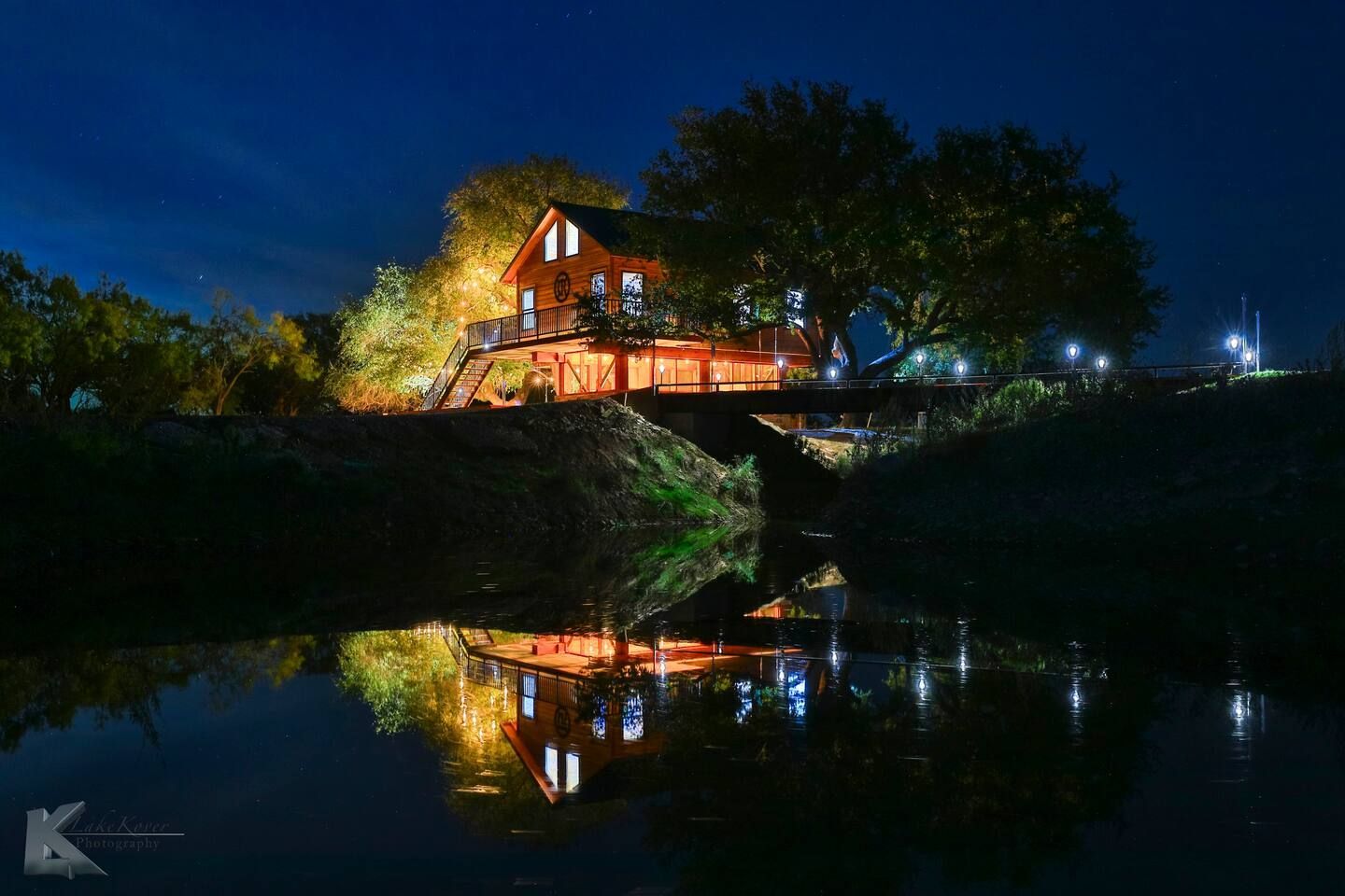 The Magic Tree House rental property in Baird Texas is lit up at night with trees in the background . The Best Texas Ranch Rentals. 