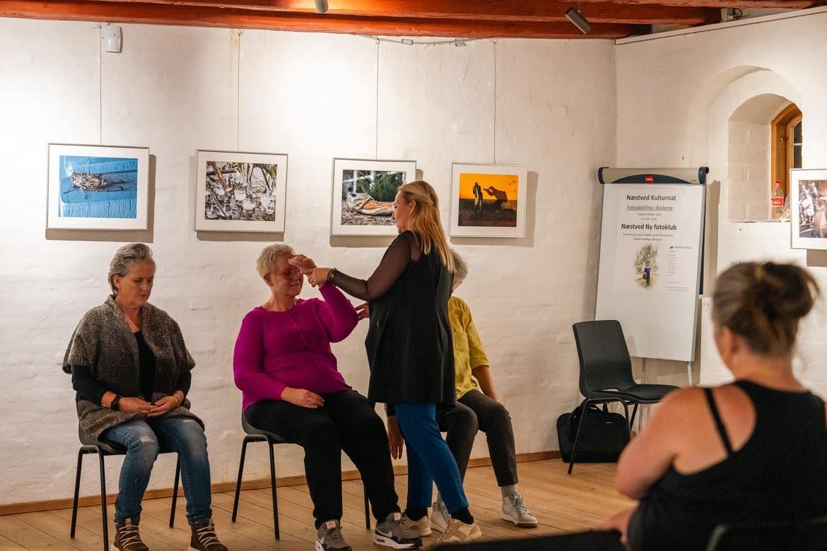 Kvinde hjælper en anden kvinde med at holde armen oppe ved pangen