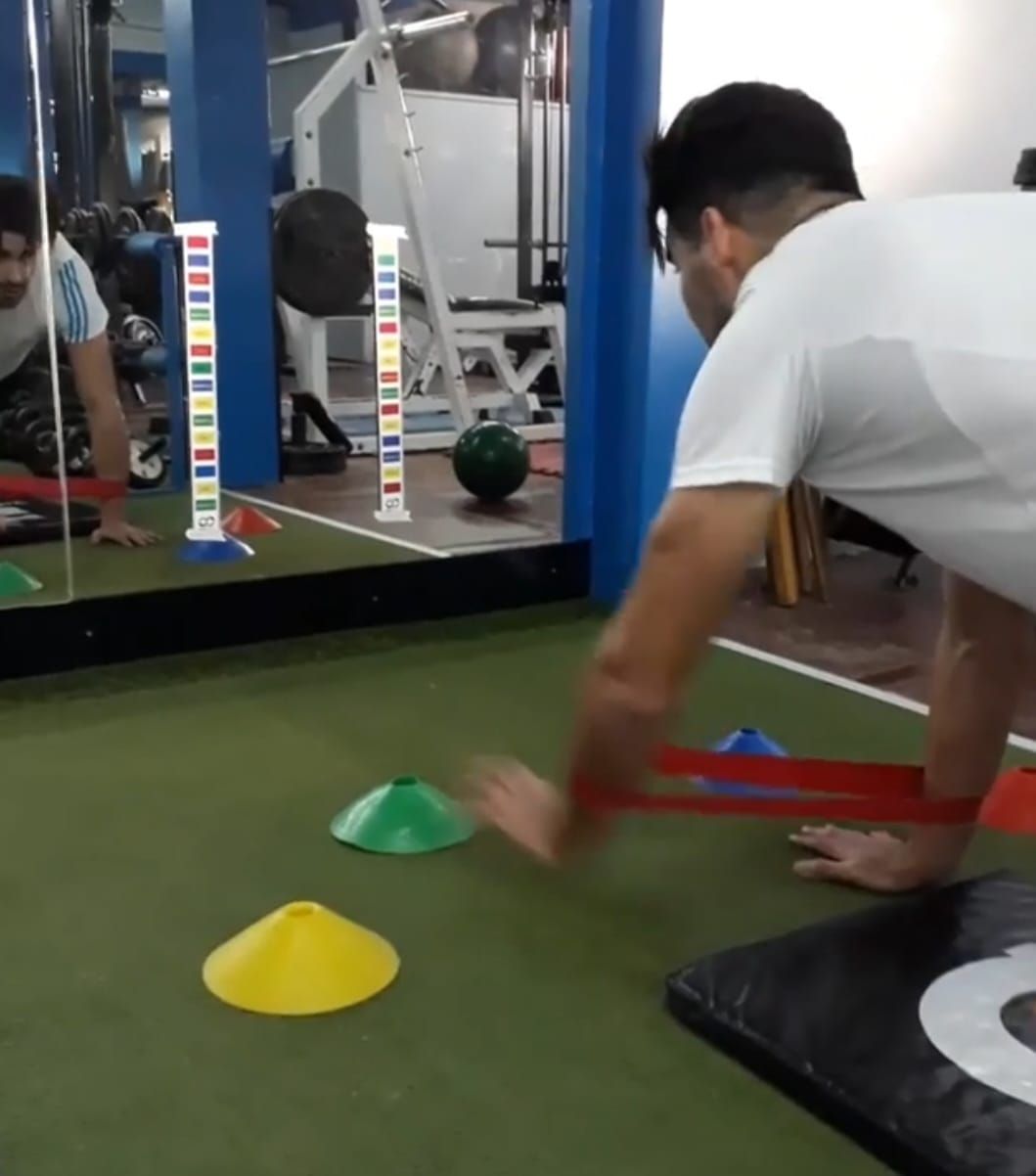 Un hombre está usando una banda de resistencia en un gimnasio.