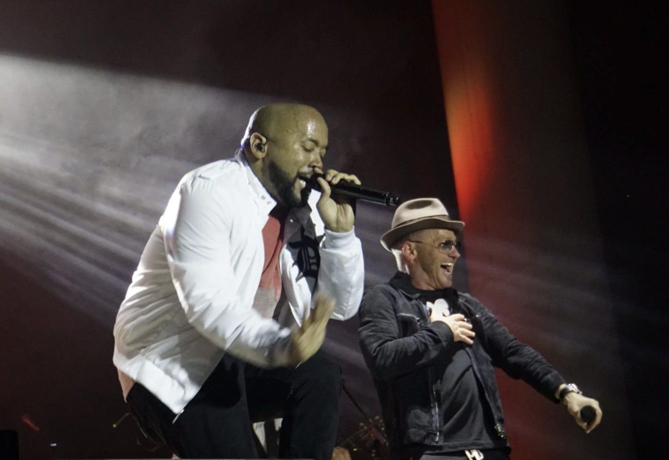 A bride and groom are dancing with their wedding party at their wedding reception.