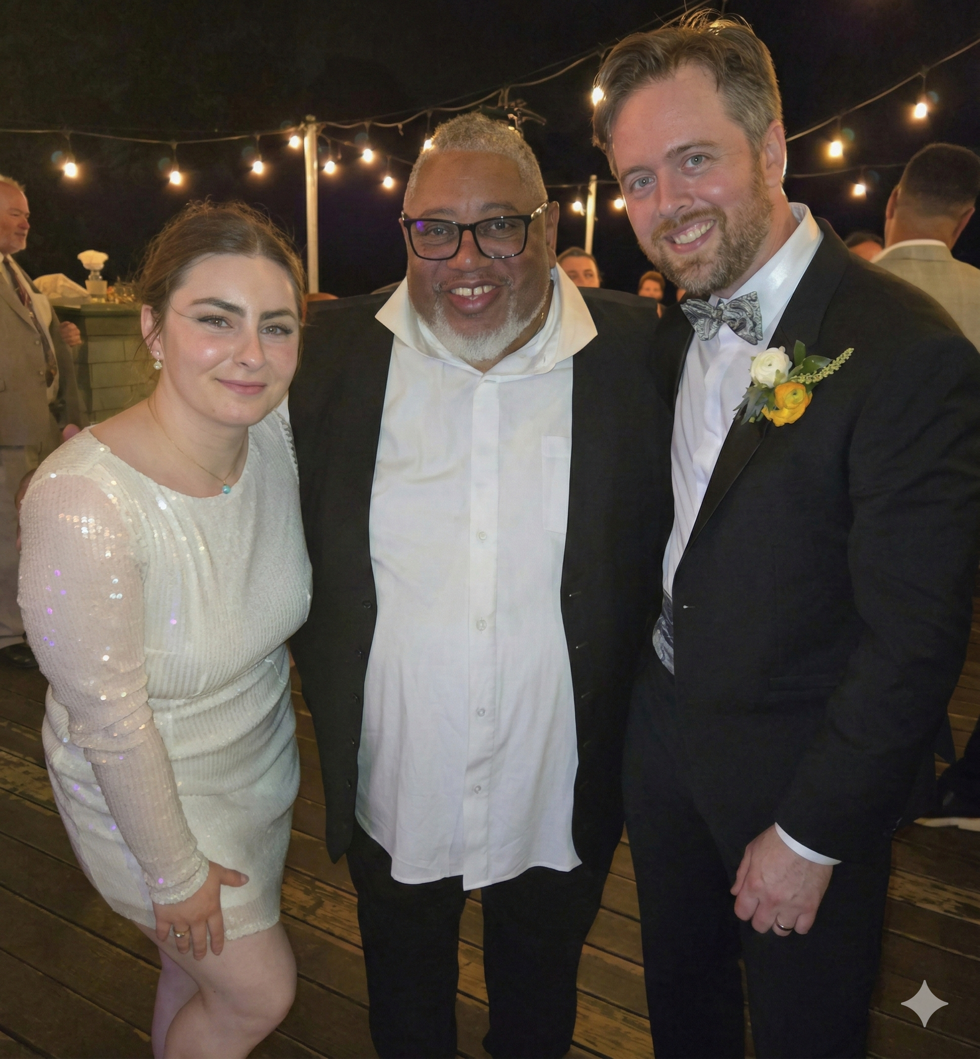 A man in a tuxedo is taking a selfie in front of a speaker