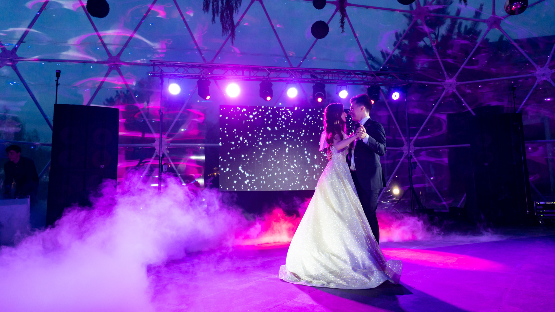 A bride and groom are dancing their first dance at their wedding reception.