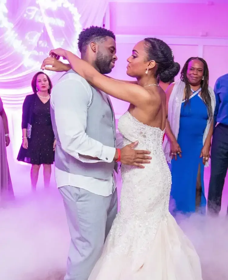 A bride and groom are dancing in front of sparklers at their wedding reception.