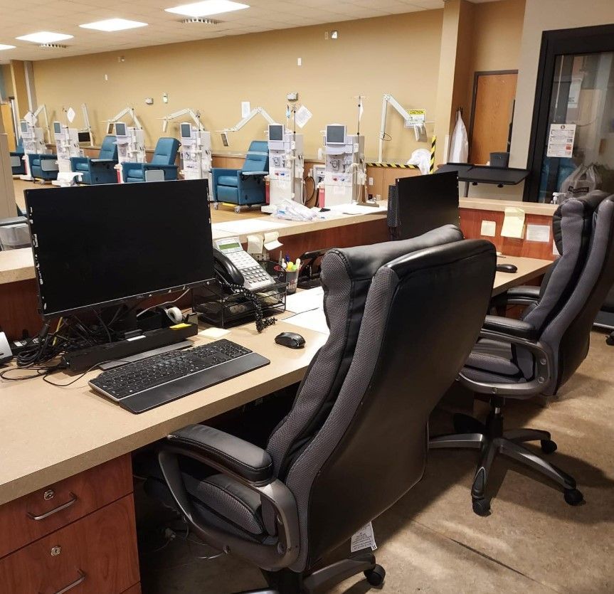 Medical office with desks, chairs, and dialysis machines; healthcare setting.