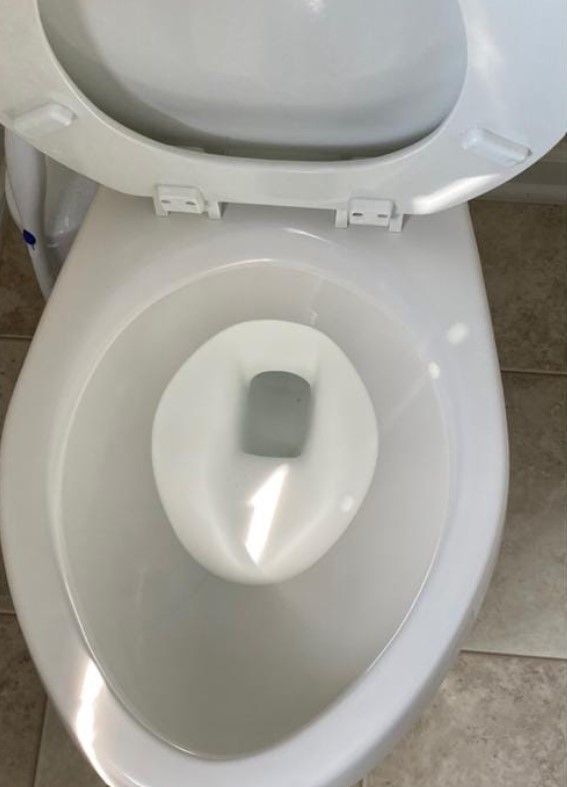 Top-down view of a white toilet bowl with the seat open.