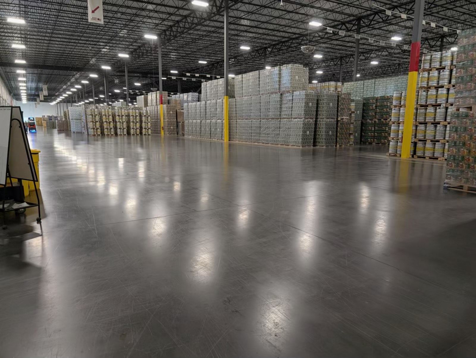 Large warehouse with stacks of goods and a polished concrete floor.