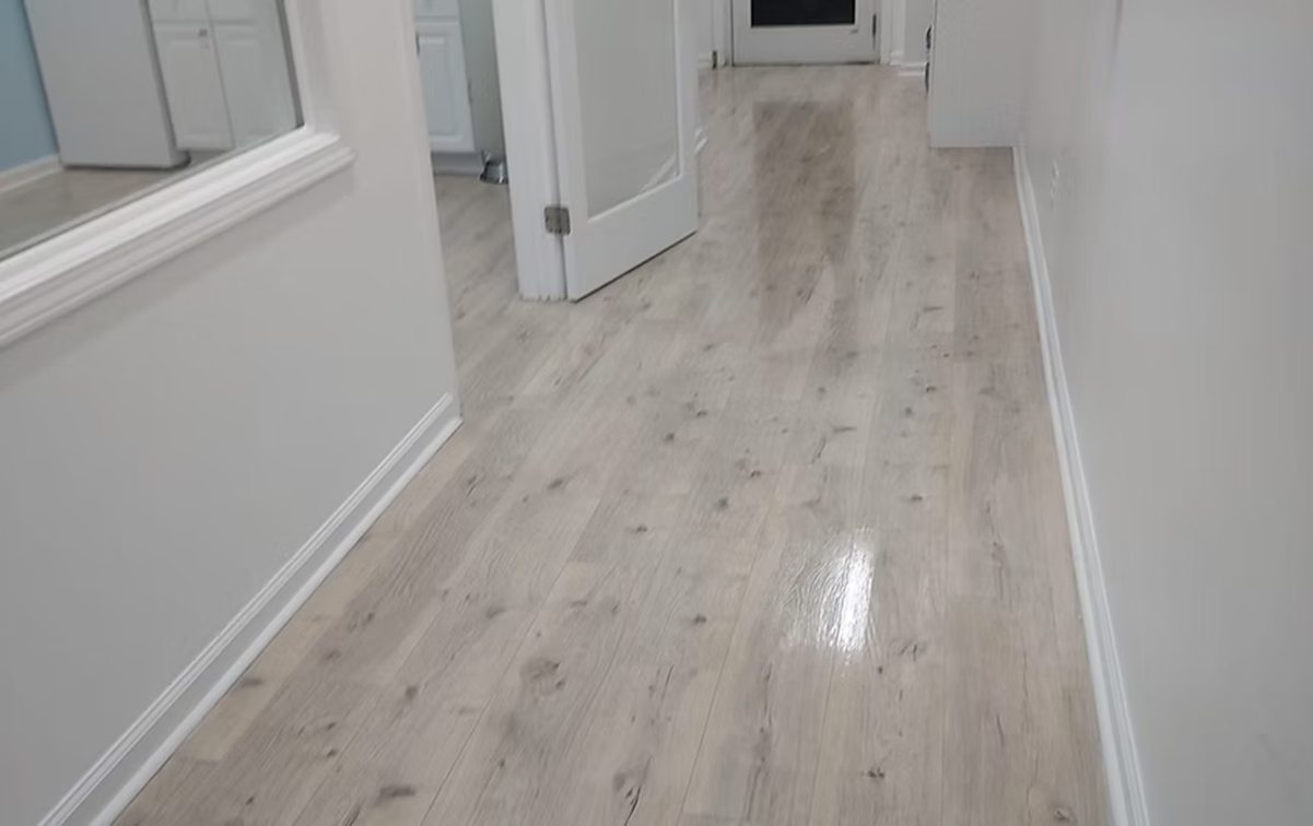A hallway with a wooden floor and white walls.