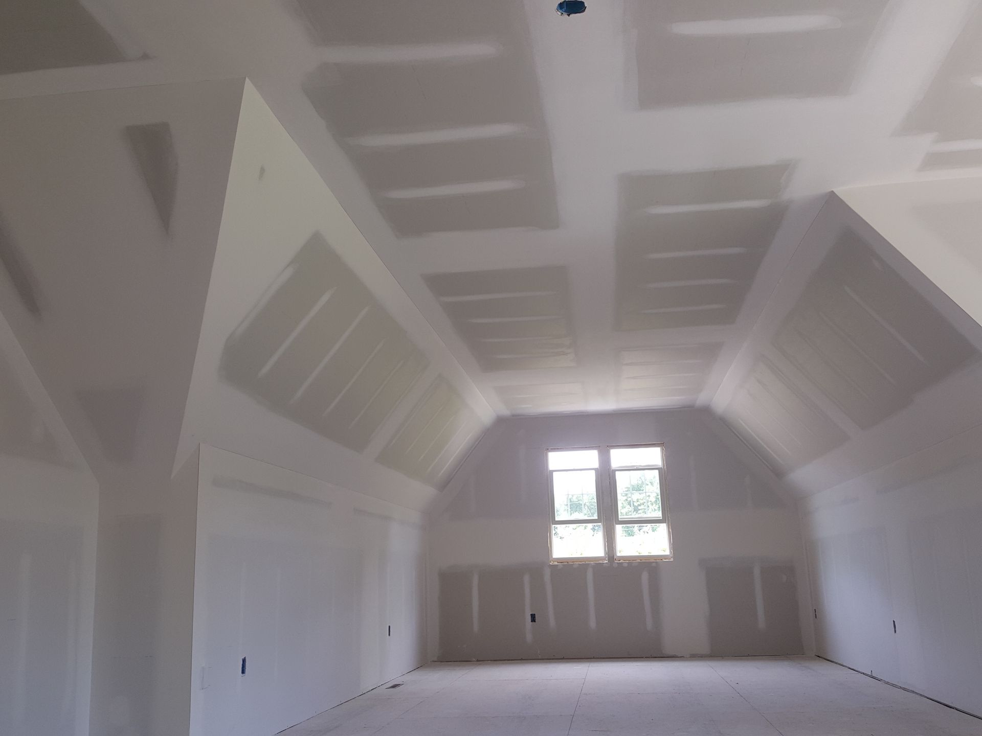 A room with a vaulted ceiling and a window