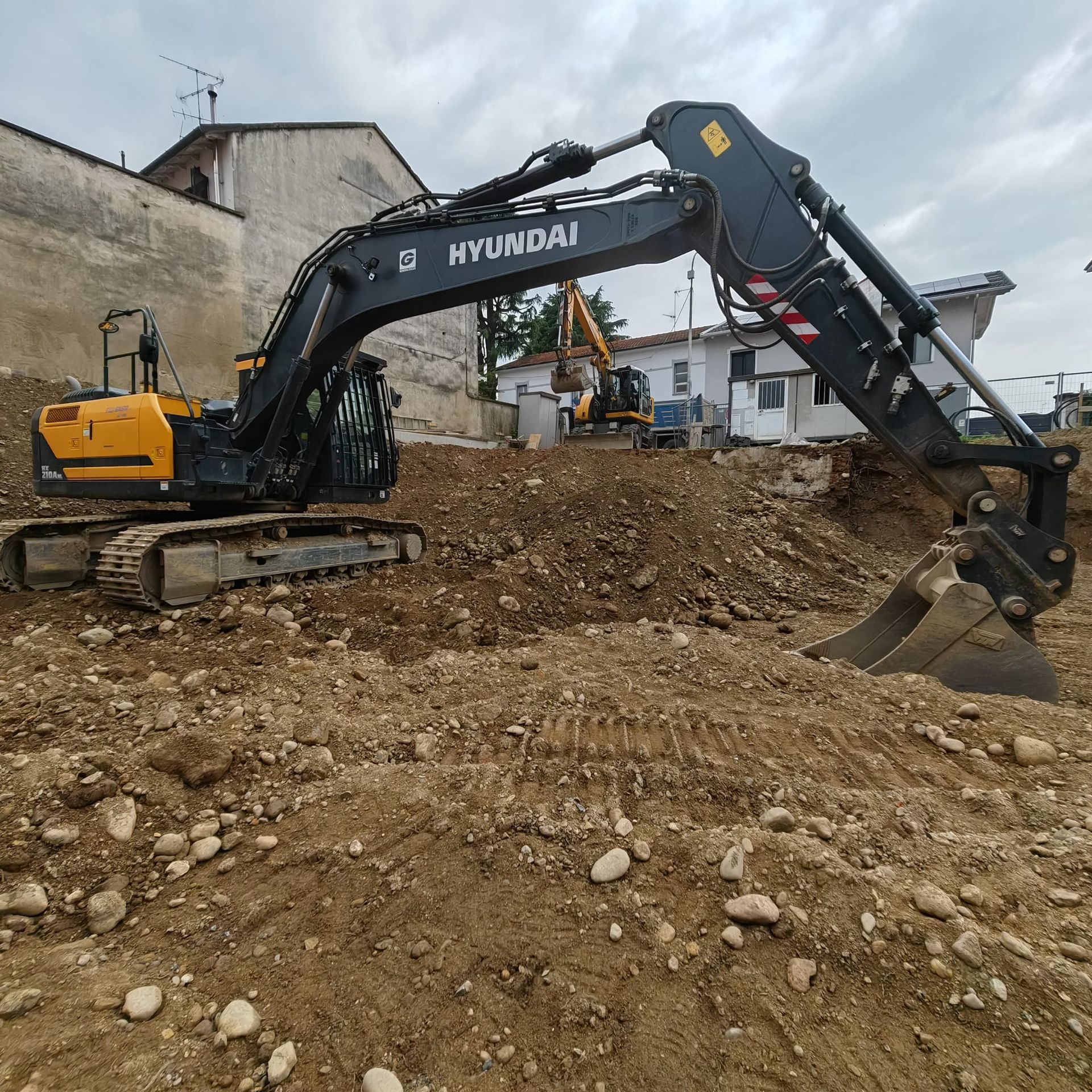 Due escavatori sono seduti in una pozzanghera di fango.