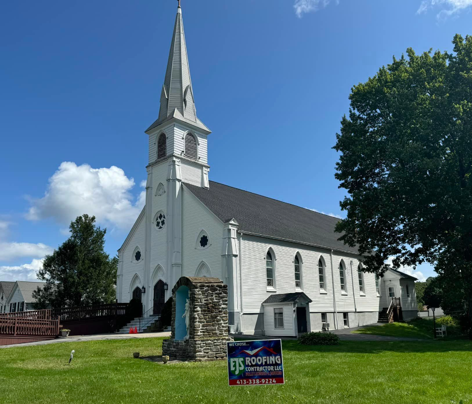 A large stone building with a tree in front of it