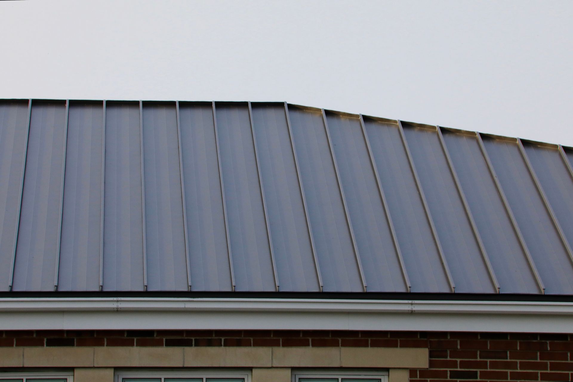 The roof of a brick building has a metal roof