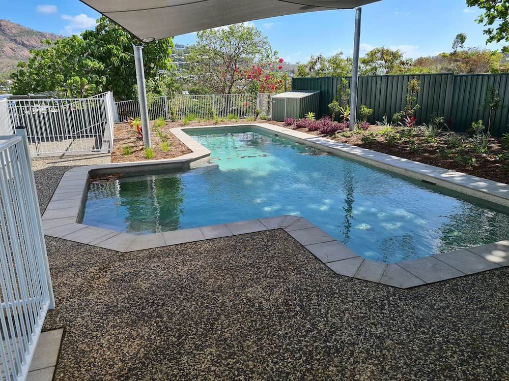 There is a Large Swimming Pool in the Backyard of a House — Lynams Landscapes Pty Ltd in Douglas, QLD