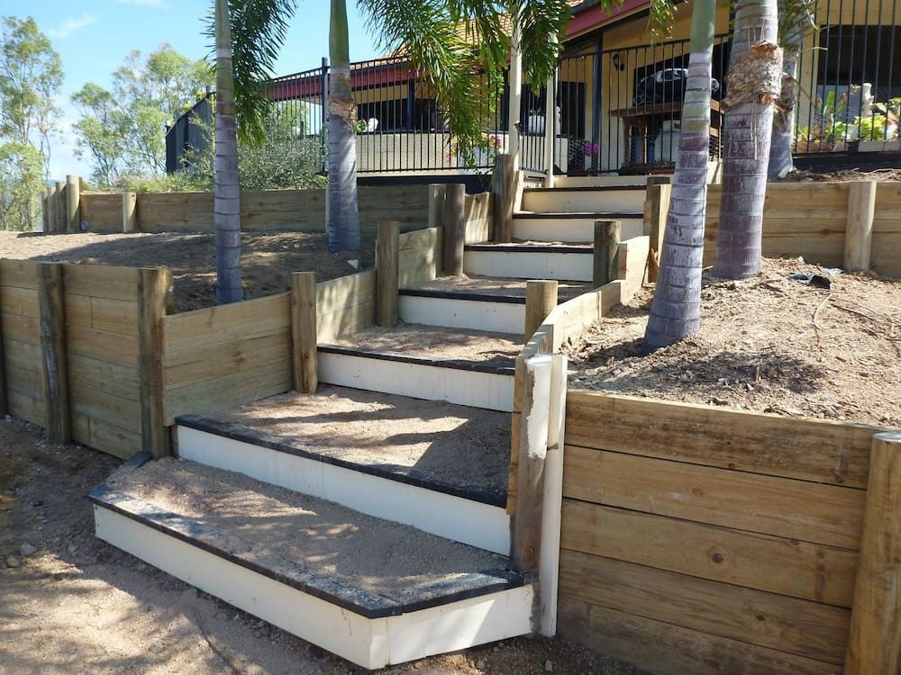 A Set of Wooden Stairs Leading Up to a House — Lynams Landscapes Pty Ltd in Townsville, QLD