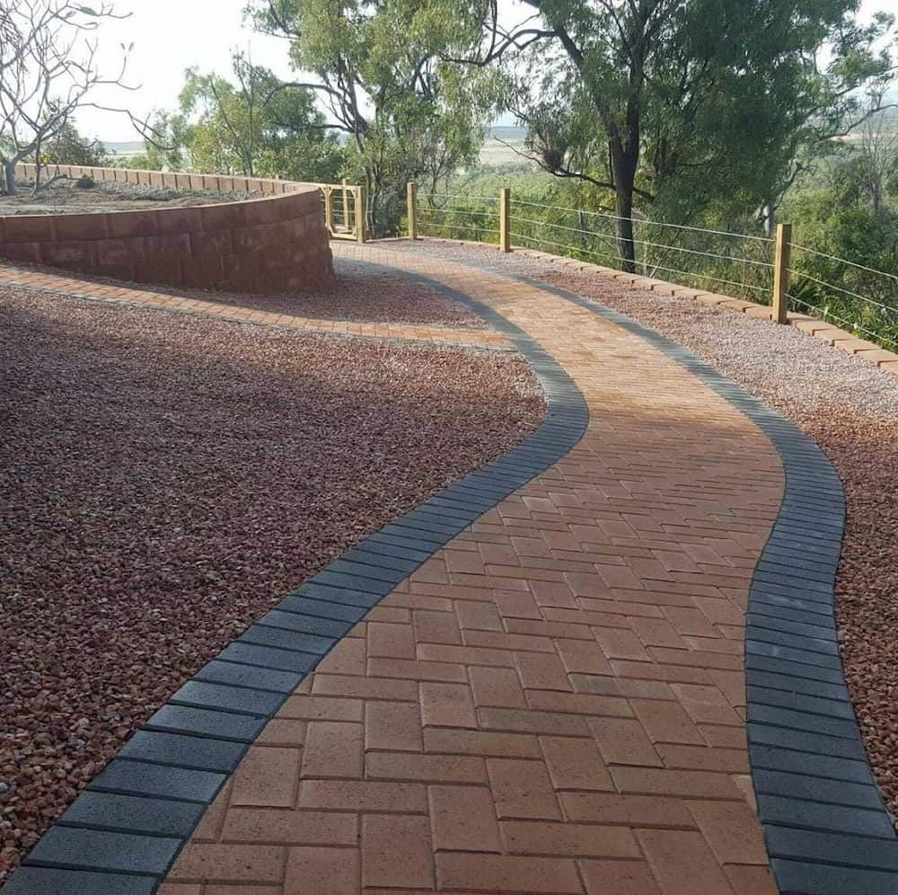 A Brick Walkway With a Fence in the Background — Lynams Landscapes Pty Ltd in Alligator Creek, QLD