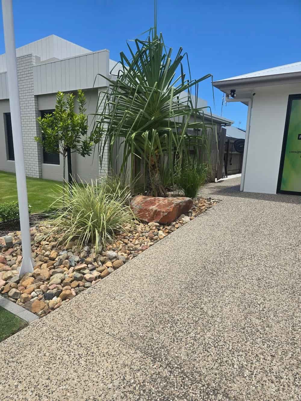 A Driveway Leading to a House With a Lot of Rocks and Plants — Lynams Landscapes Pty Ltd in Jensen, QLD