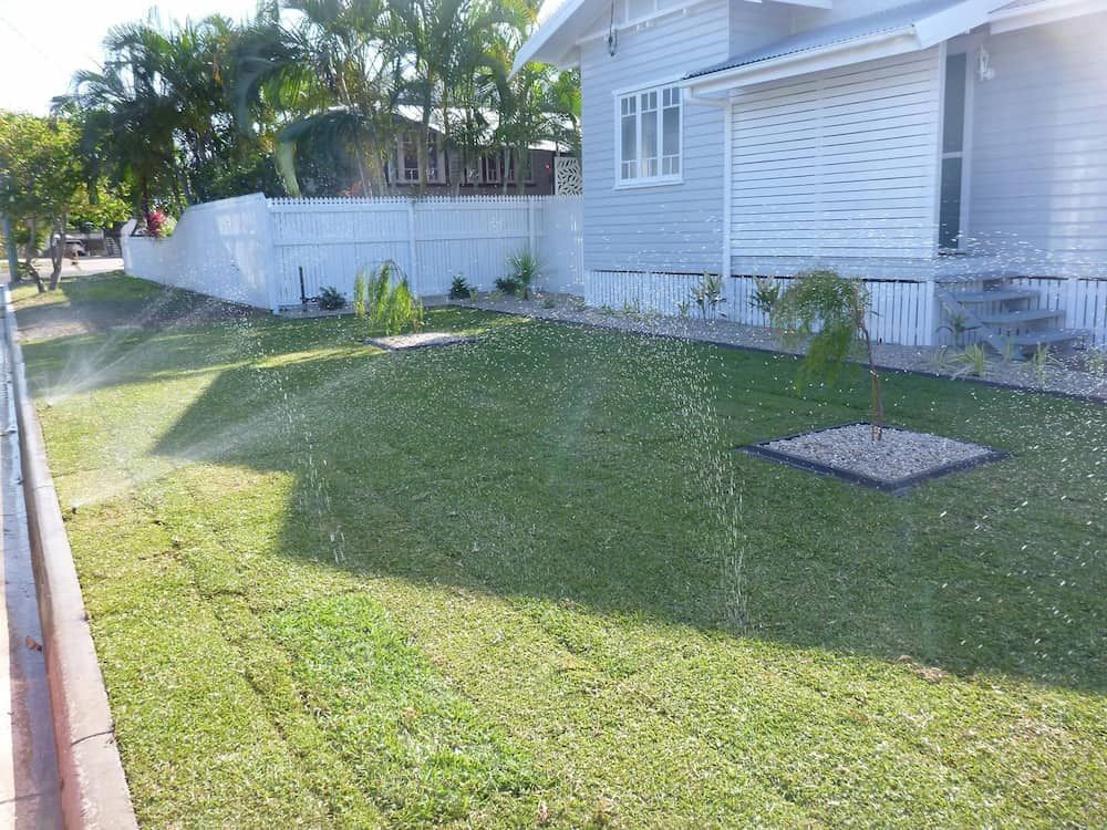 The Backyard of a House With a Wooden Fence and a Lot of Grass — Lynams Landscapes Pty Ltd in Jensen, QLD
