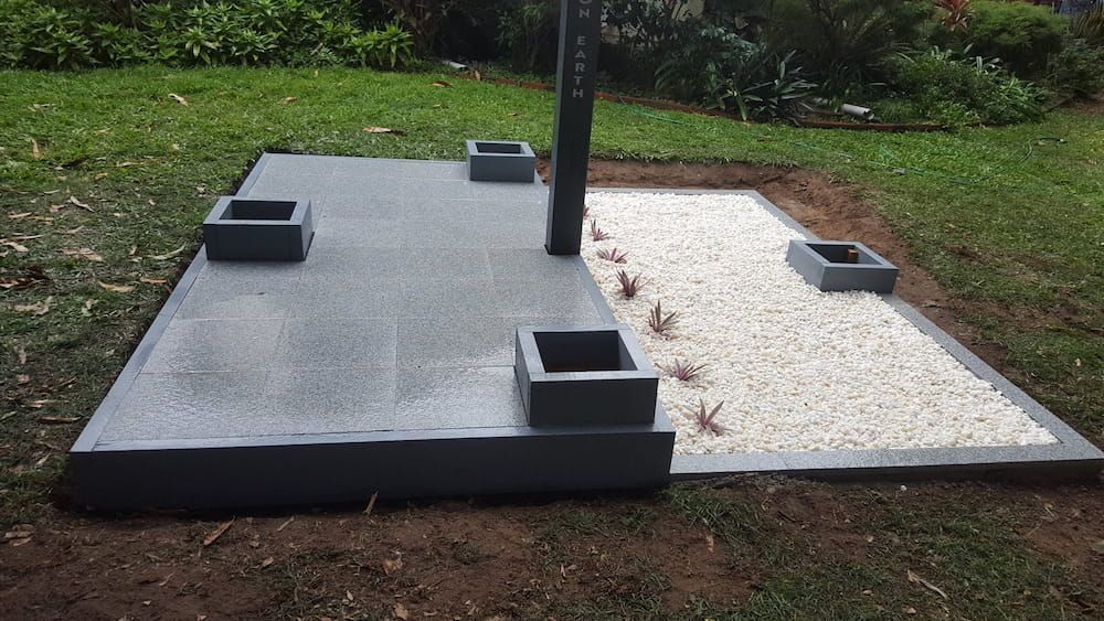 A Concrete Platform With Planters and Gravel in a Yard — Lynams Landscapes Pty Ltd in Mount Louisa, QLD