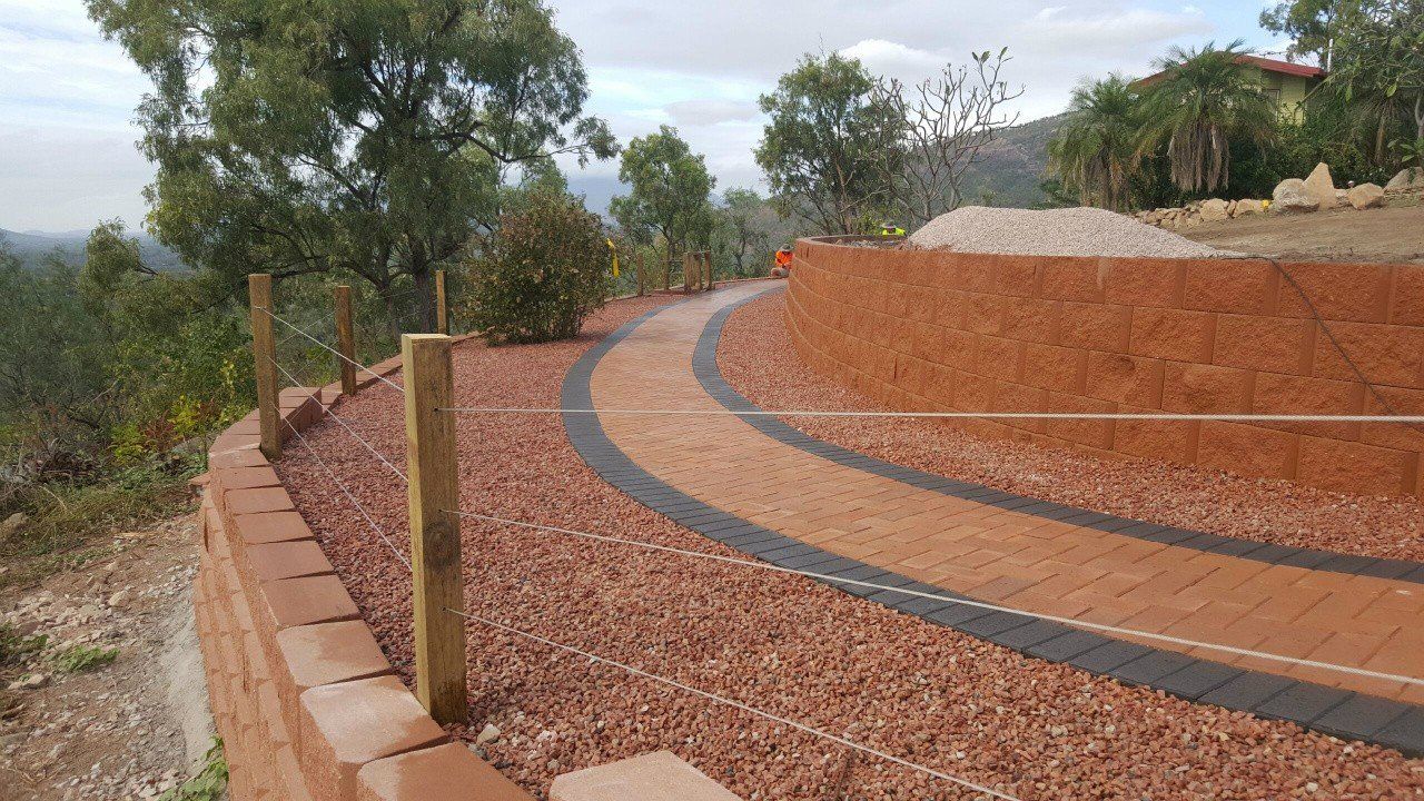 A Dirt Road With a Wooden Post on the Side of It — Lynams Landscapes Pty Ltd in Jensen, QLD