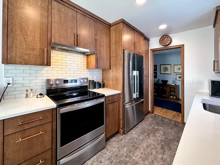 Kitchen with wood cabinets, stainless steel appliances, and white countertops.
