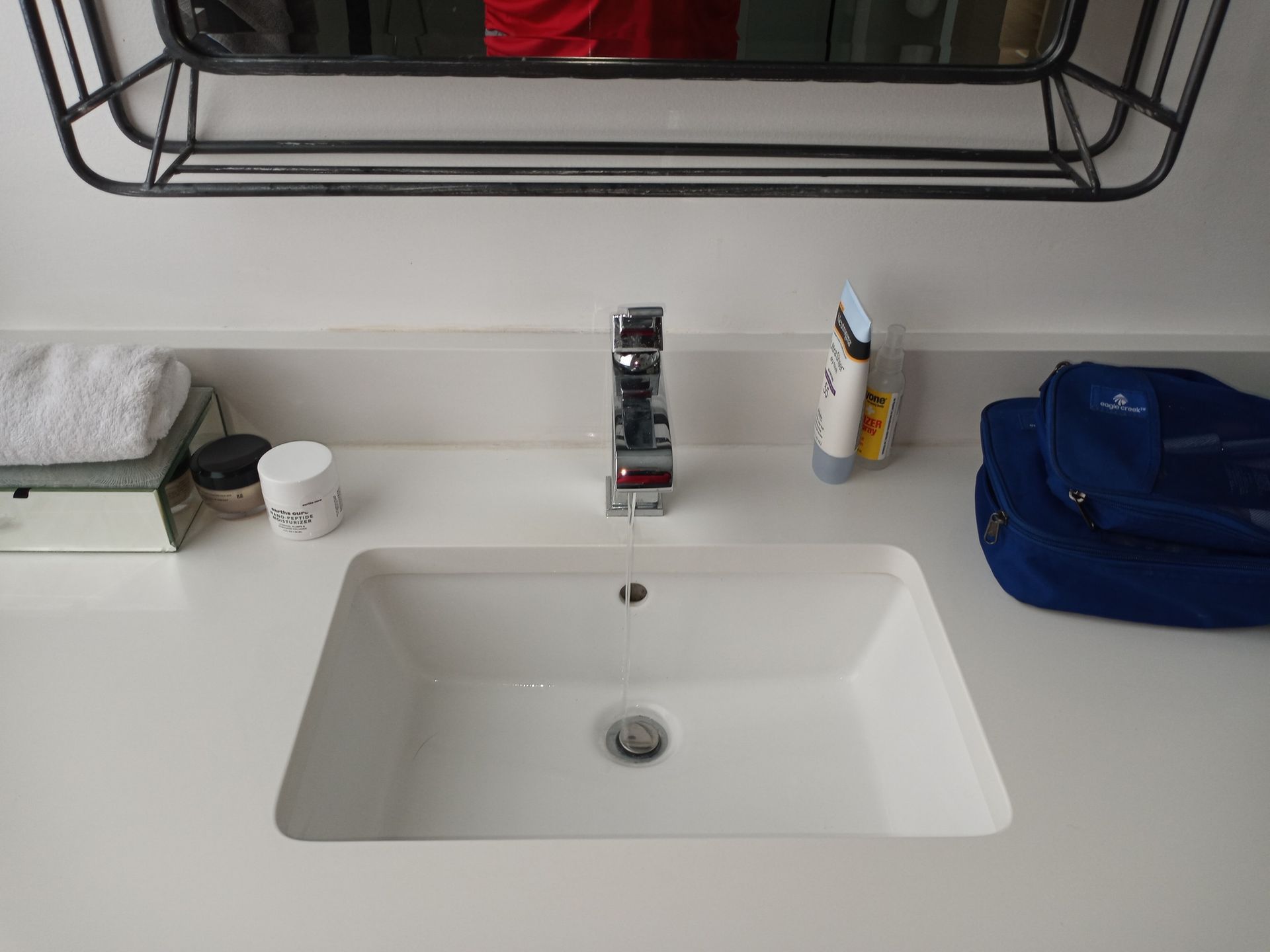 a bathroom sink with a faucet and a blue bag on the counter .