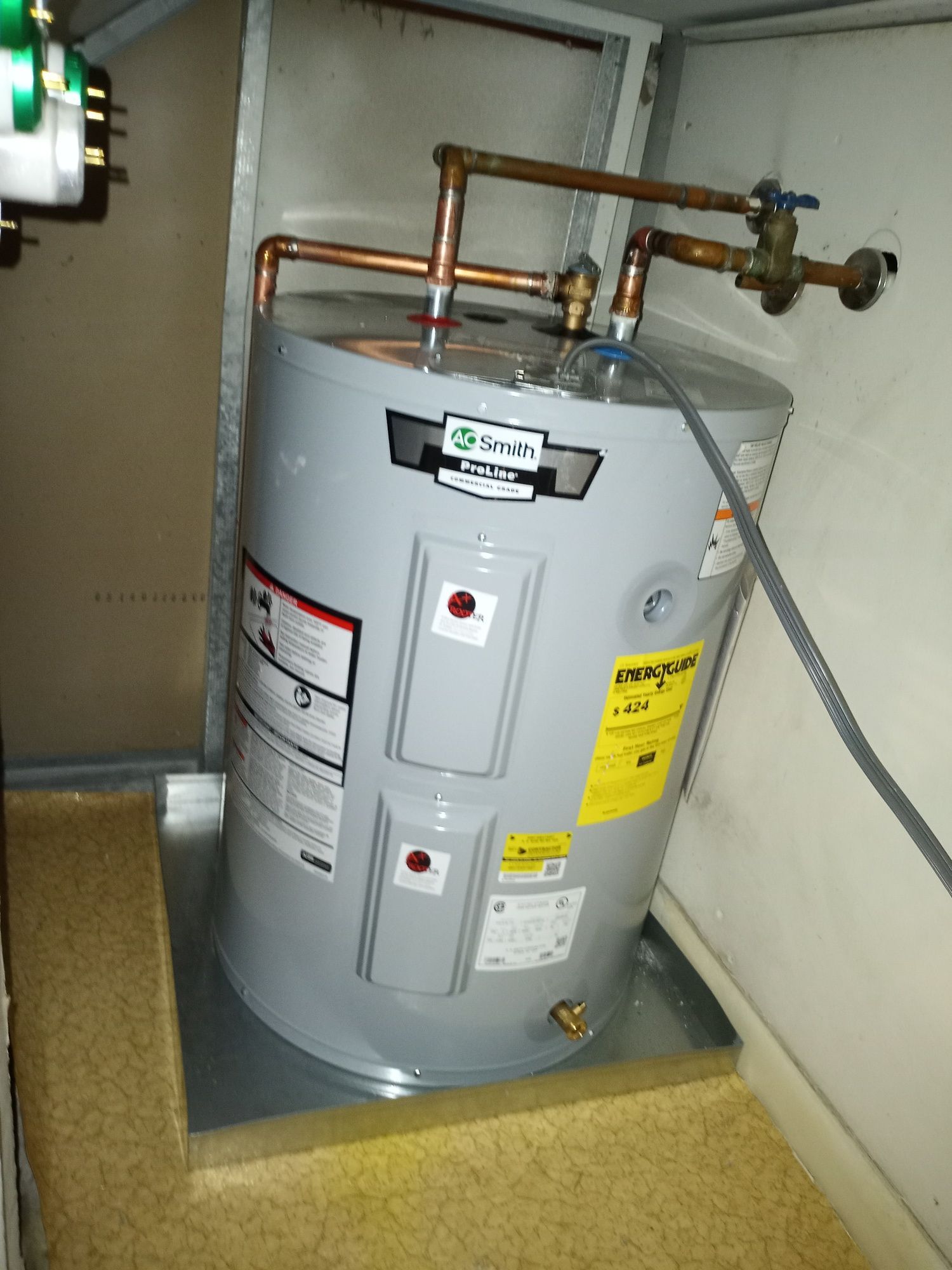 a water heater is sitting on the floor in a room .