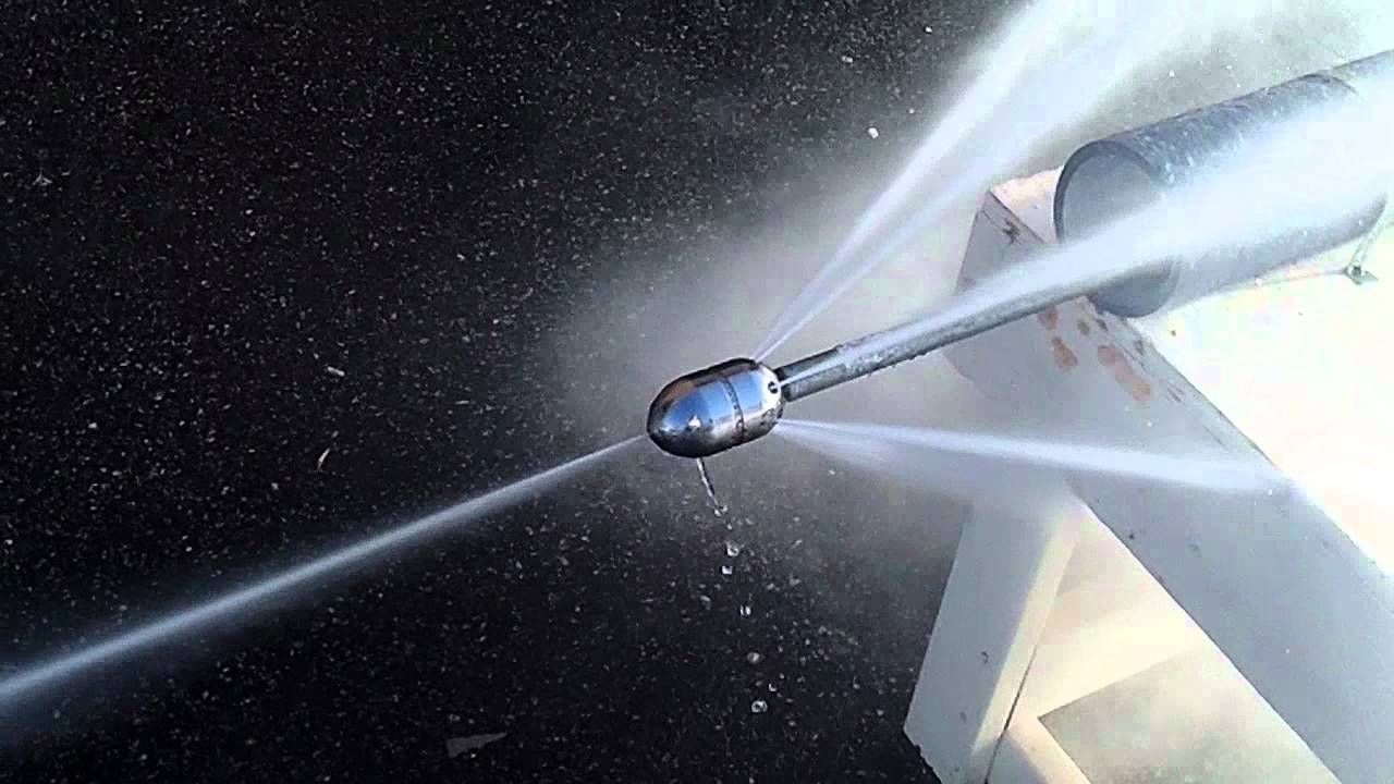 a close up of a high pressure washer spraying water on a pipe .