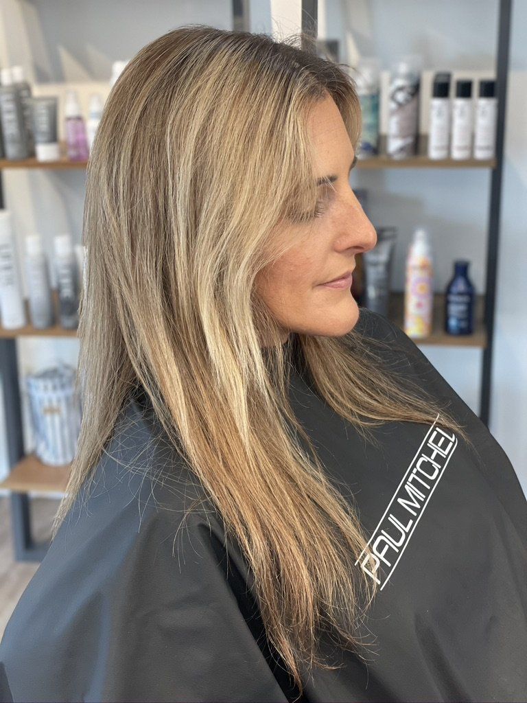 A woman is getting her hair cut in a salon.