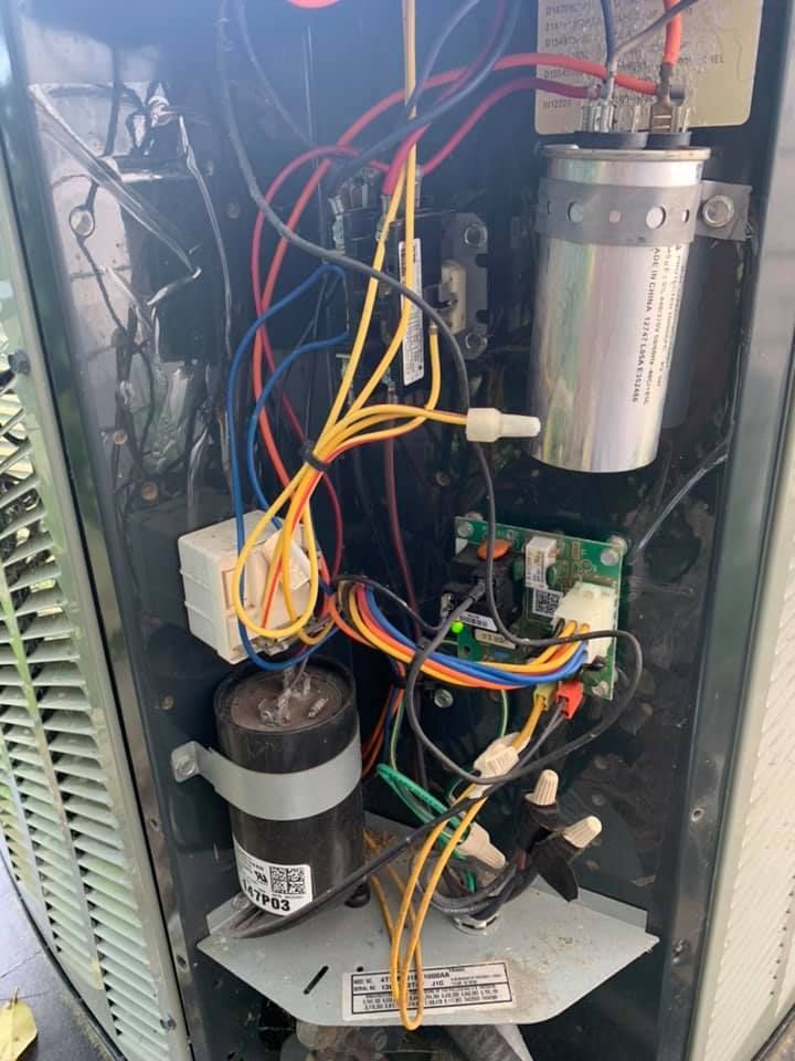 The inside of an air conditioner with a lot of wires coming out of it