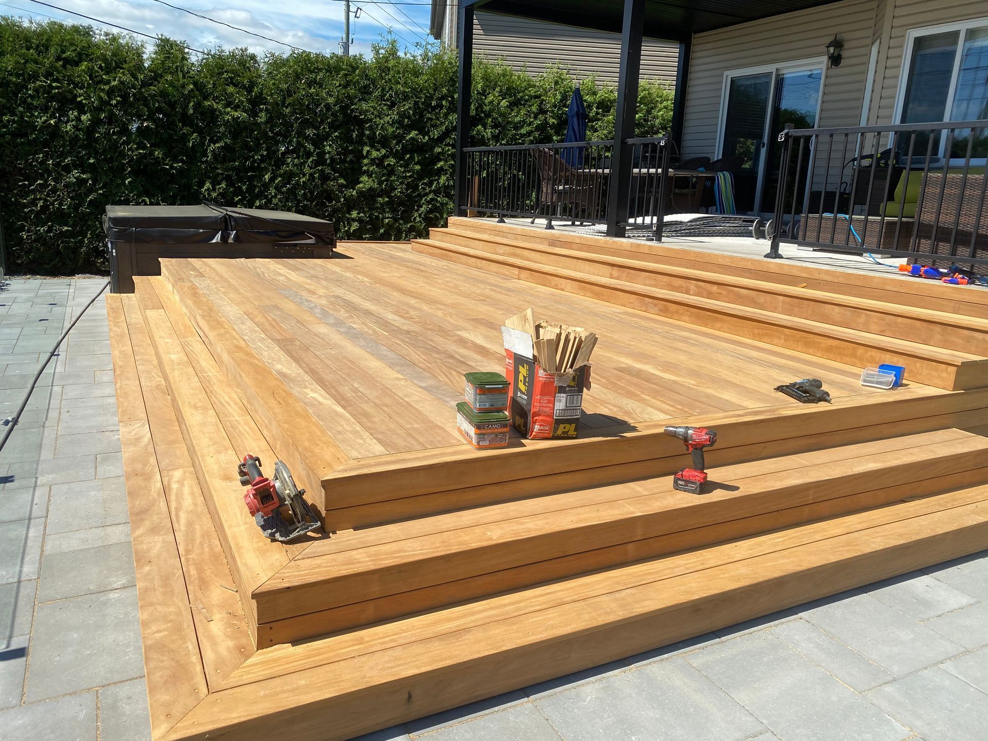 Une terrasse en bois est en cours de construction devant une maison.