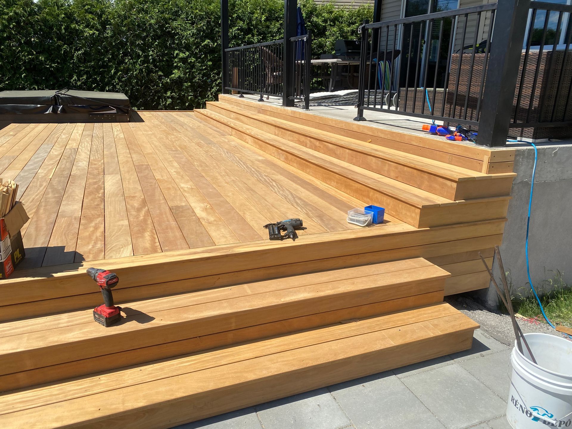 Une terrasse en bois avec des escaliers et une perceuse dessus
