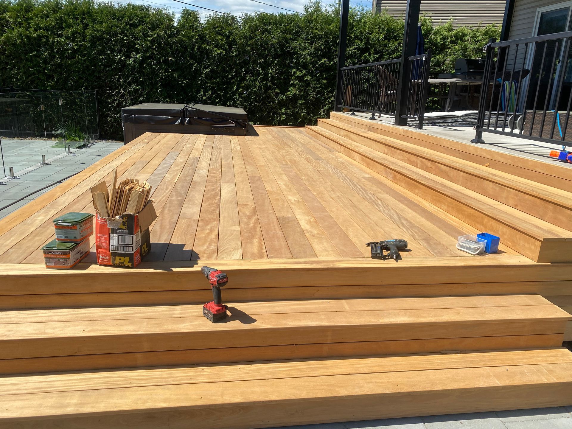Une perceuse est posée sur une terrasse en bois.
